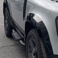 Front side view of black Union Jack side steps installed on Land Rover Defender L663