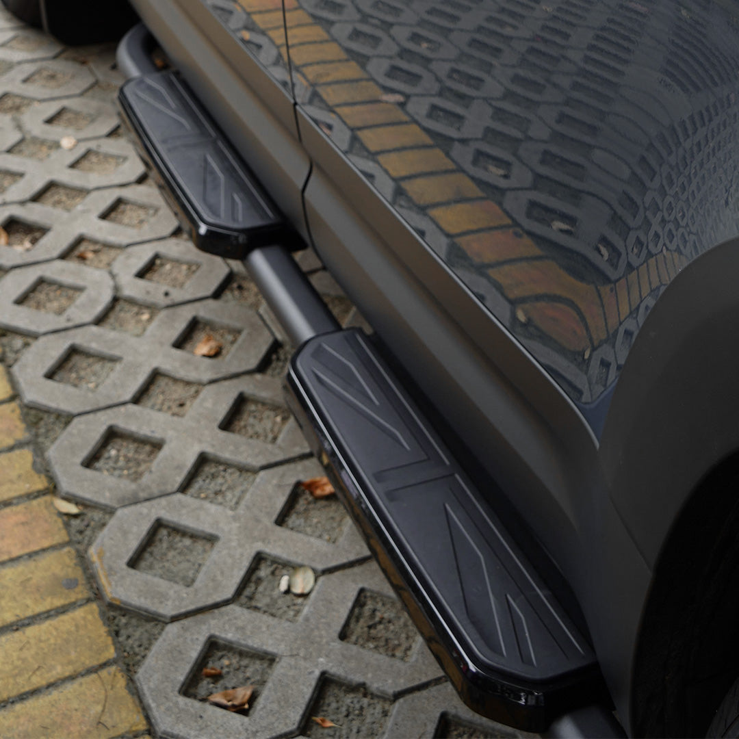 Detail view of black Union Jack side steps installed on Land Rover Defender L663