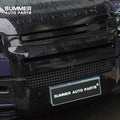 Close-up of installed gloss black front grille and bumper trim on Land Rover Defender L663